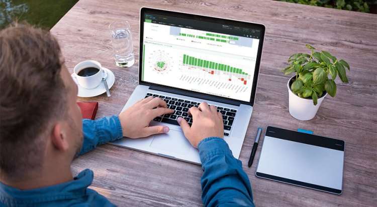 Чоловік працює з Yaware TimeTracker для контролю та обліку робочого часу на ноутбуці